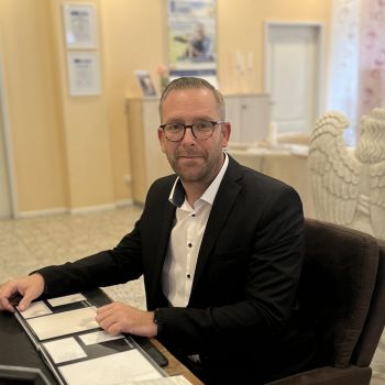 Bestatter & Filialleiter Marc Fischer von Bestattungen Hampel blättert am Schreibtisch in Traueranzeigen